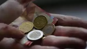 Main tenant des pièces et des billets en euros, indiquant que les paiements en espèces sont acceptés chez Ty Flam's Food Truck.